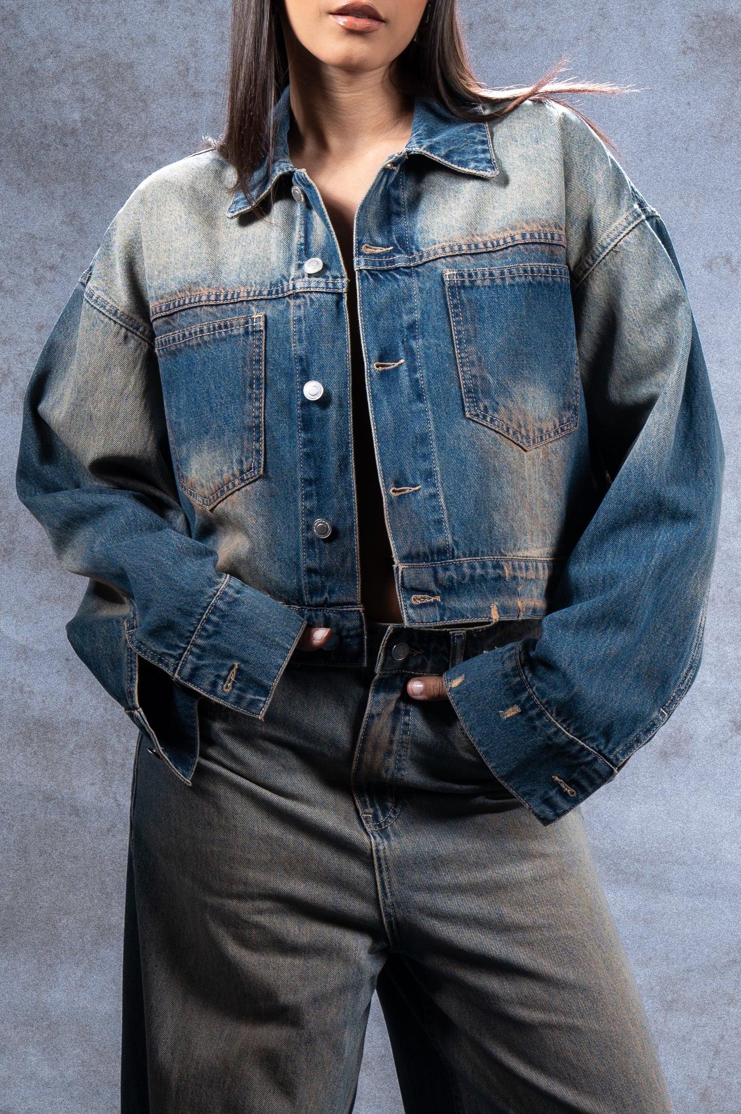 Wide denim jacket made of 100% Egyptian cotton blend- Cut to an oversized fit with dropped shoulders, extra long sleeves and cropped length. Fading and smudging throughout detailing.