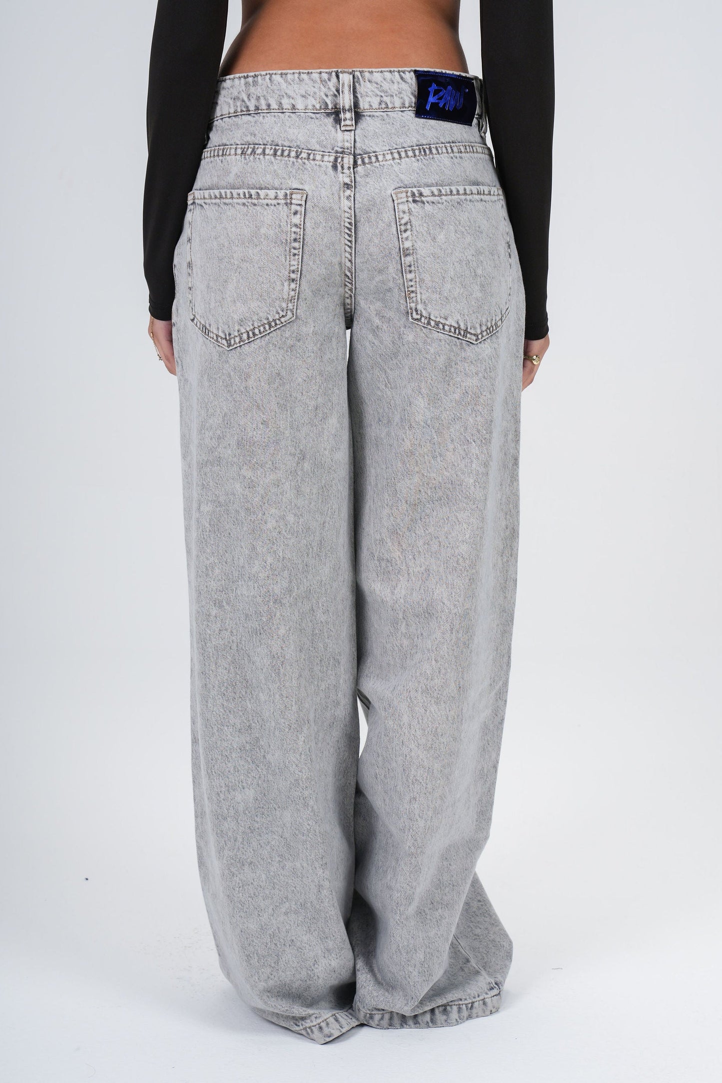 Person wearing gray wide-leg jeans on a white background