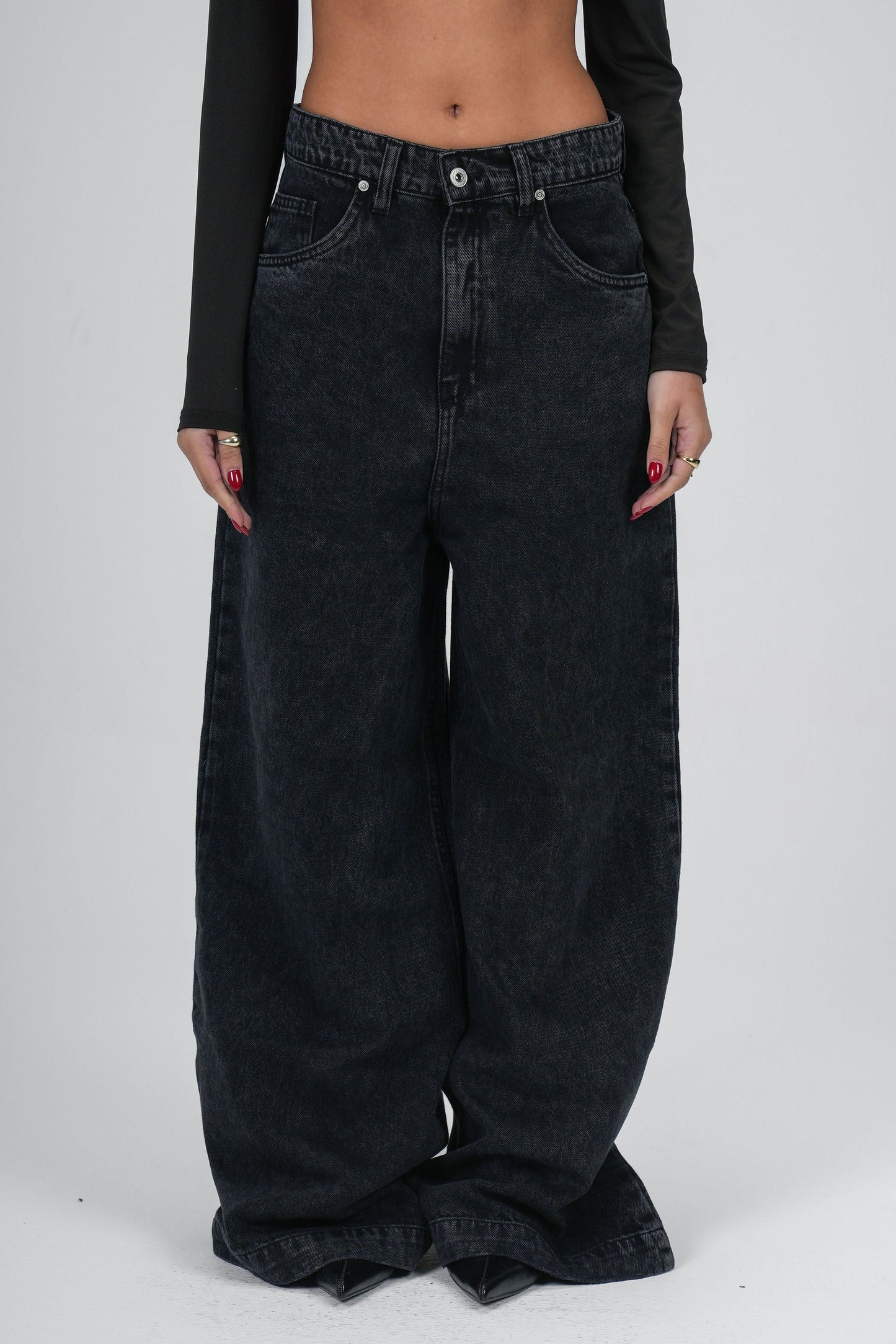 Black wide-leg jeans worn by a person on a white background