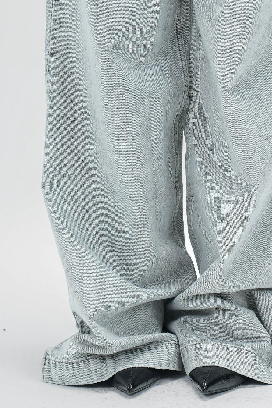 Person wearing light gray high-waisted jeans on a white background